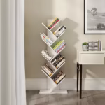 White Branch Book Tower featuring a bright white vertical column with multiple tilted branch-like shelves holding books, anchored by a heavy square base.