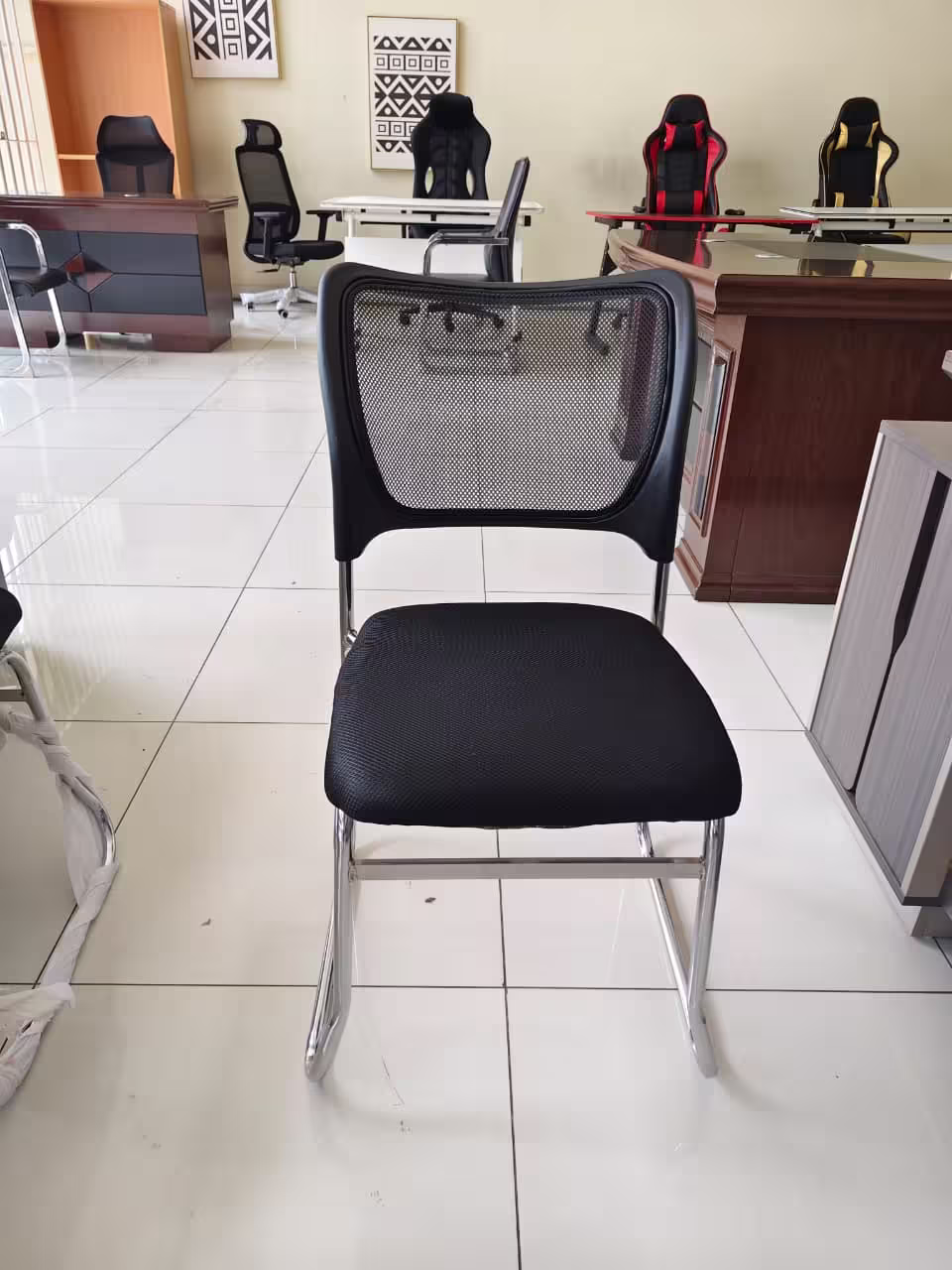 Black mesh waiting office chair with cushioned seat and metal frame