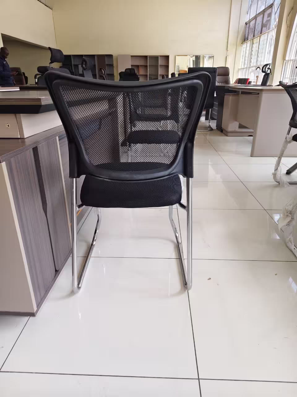 Black mesh waiting office chair with cushioned seat and metal frame
